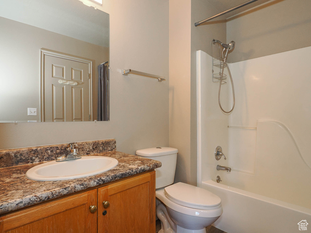Full bathroom with shower / tub combo, vanity, and toilet