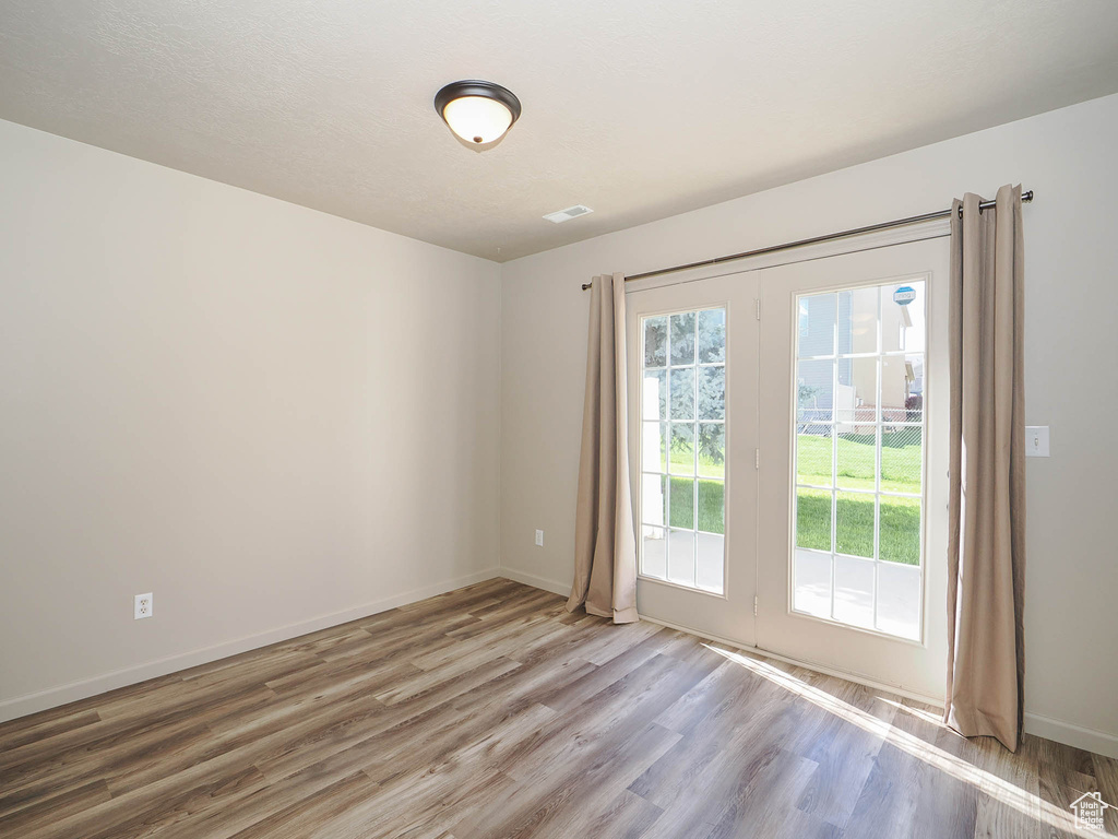 Spare room with hardwood / wood-style flooring and french doors