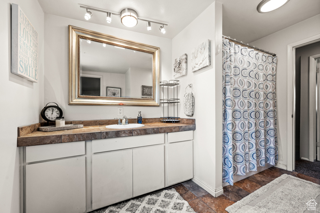 Bathroom featuring tile flooring, vanity, and rail lighting