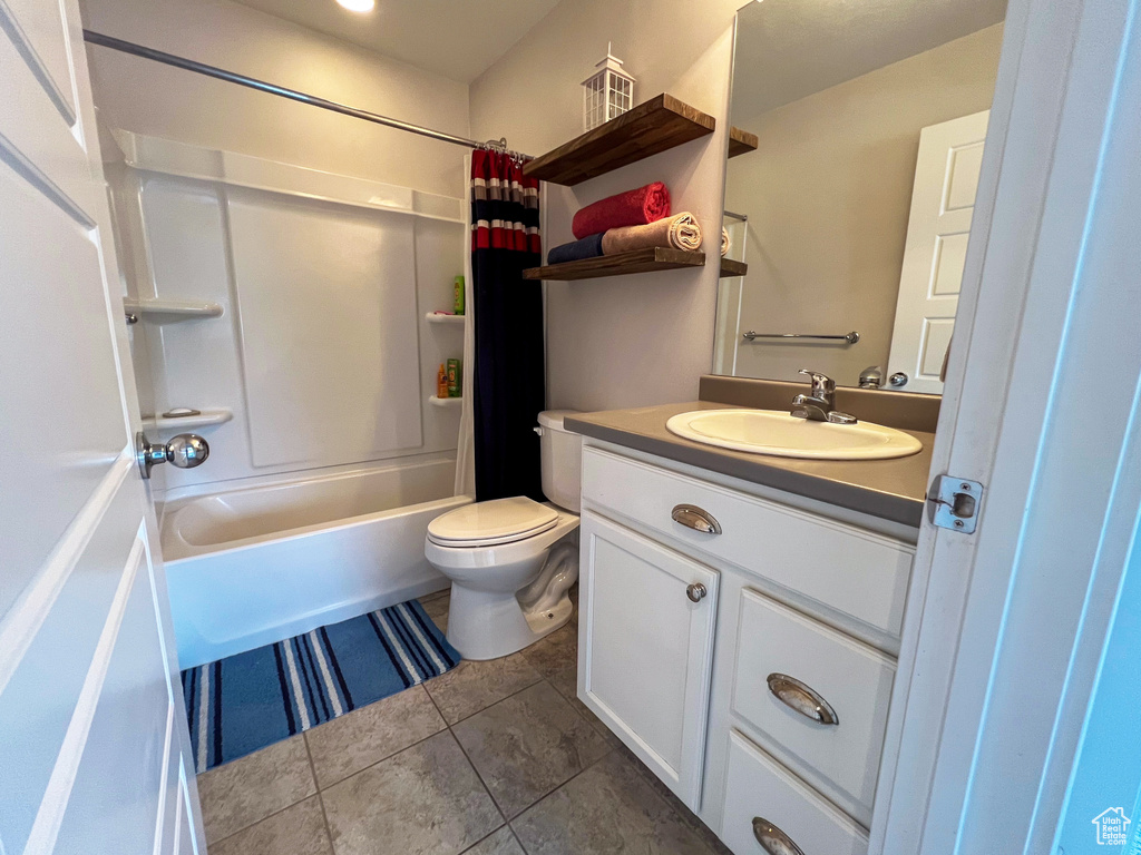 Full bathroom with shower / tub combo with curtain, oversized vanity, toilet, and tile flooring
