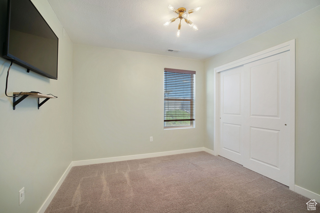 Unfurnished bedroom with carpet and a closet