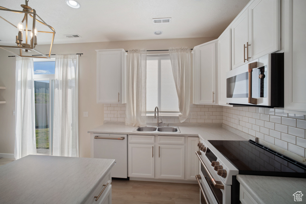 Kitchen featuring tasteful backsplash, stainless steel appliances, light hardwood / wood-style floors, and sink