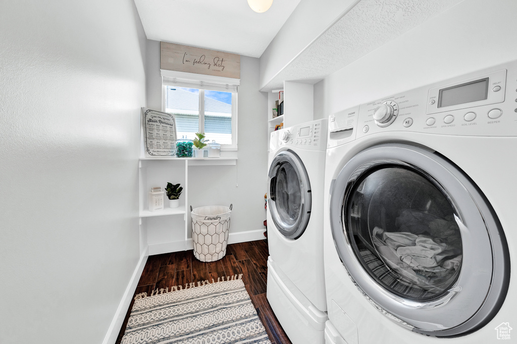 Clothes washing area with hardwood / wood-style floors and washer and clothes dryer