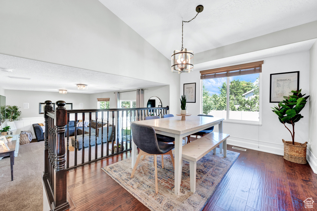 Dining space featuring a chandelier, plenty of natural light, and dark hardwood / wood-style flooring
