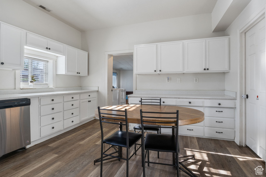 Kitchen with white cabinets, dishwasher, dark hardwood / wood-style floors, and washer / dryer