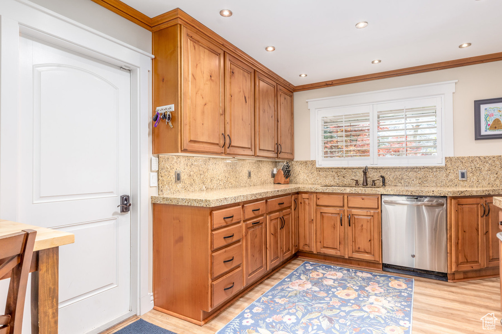 Kitchen with sink, dishwasher, tasteful backsplash, light wood-type flooring, and ornamental molding