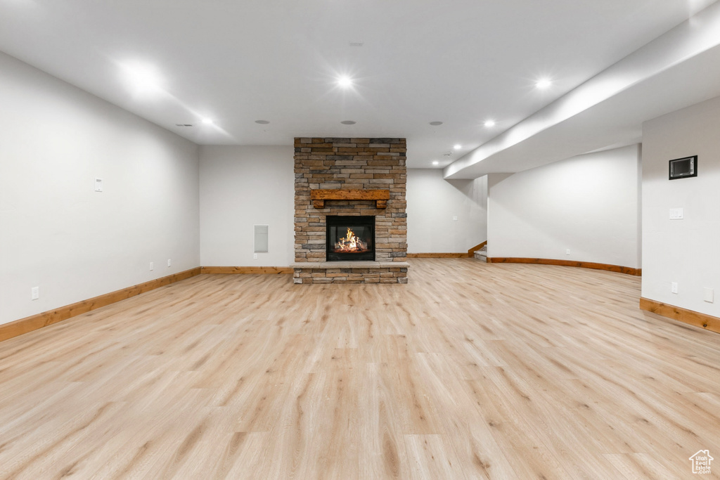 Unfurnished living room with light wood-type flooring and a fireplace