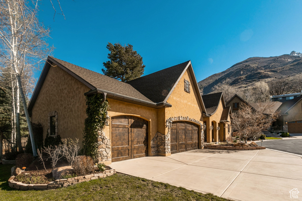 View of front of home with a mountain view and a garage