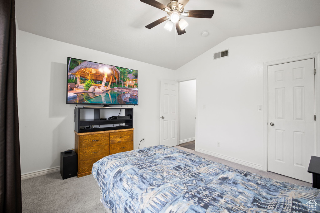 Bedroom with lofted ceiling, ceiling fan, and carpet flooring
