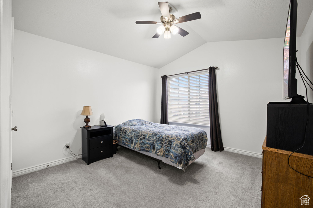 Bedroom featuring vaulted ceiling, ceiling fan, and carpet floors