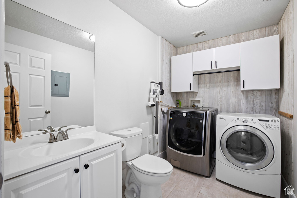 Clothes washing area with wood walls, sink, washing machine and dryer, and washer hookup