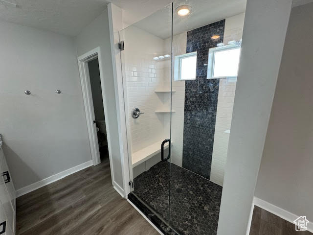 Bathroom featuring hardwood / wood-style floors, an enclosed shower, and toilet