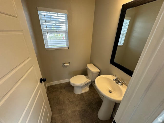 Bathroom featuring sink, tile floors, and toilet