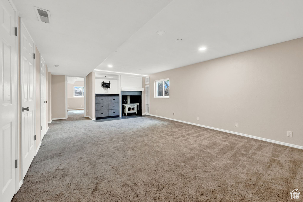 Unfurnished living room featuring plenty of natural light and carpet flooring