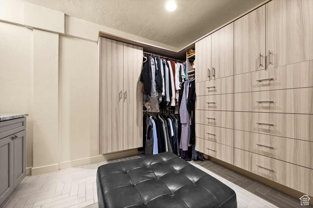 Spacious closet with dark parquet flooring