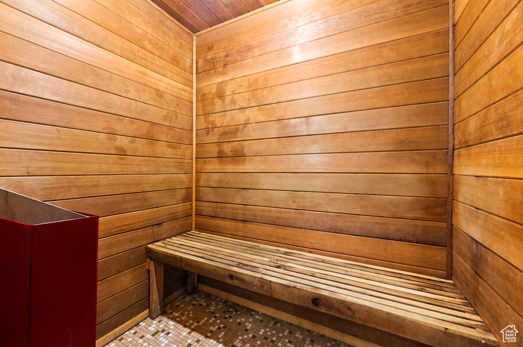 View of sauna / steam room with wooden ceiling, tile floors, and wooden walls