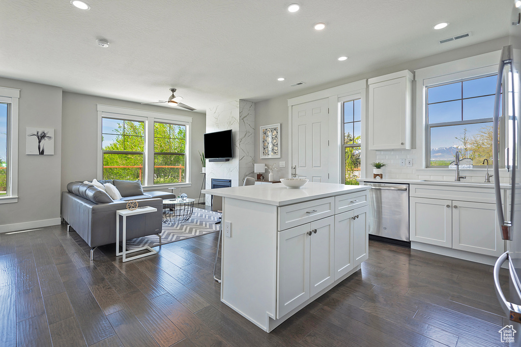 Kitchen featuring a kitchen island, dark wood-type flooring, dishwasher, and white cabinetry