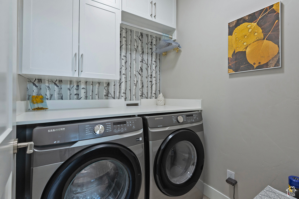 Washroom with washing machine and clothes dryer and cabinets