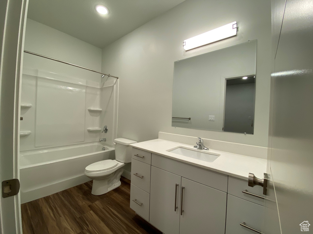 Full bathroom featuring bathing tub / shower combination, wood-type flooring, toilet, and large vanity