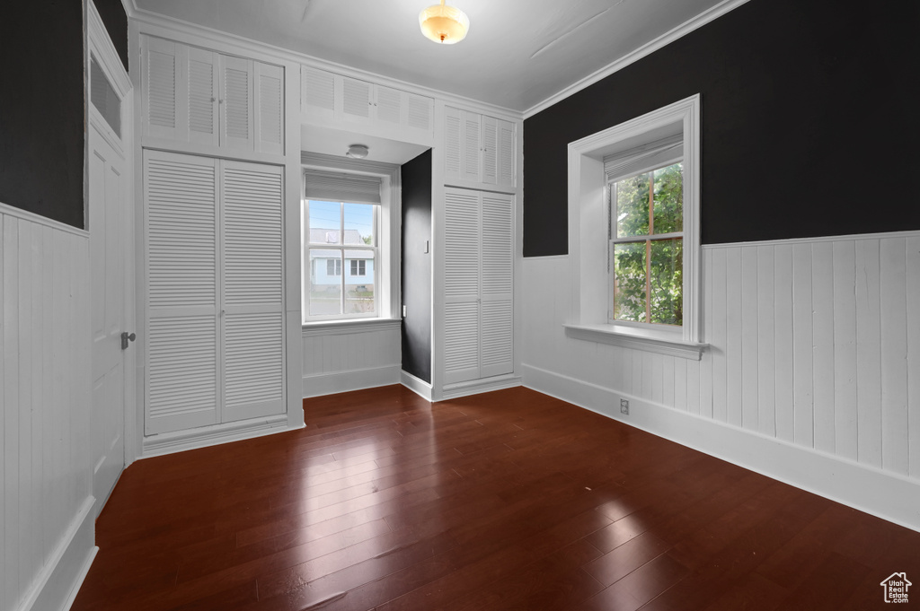 Spare room with dark hardwood / wood-style flooring and crown molding