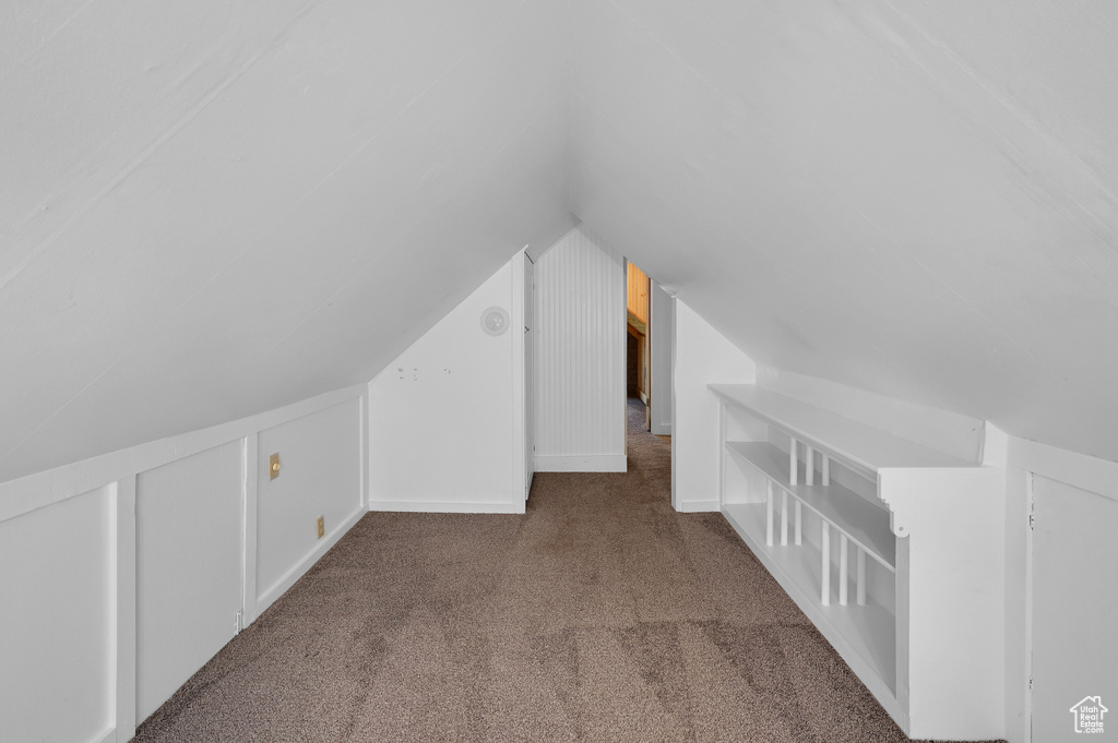 Additional living space featuring vaulted ceiling and carpet floors