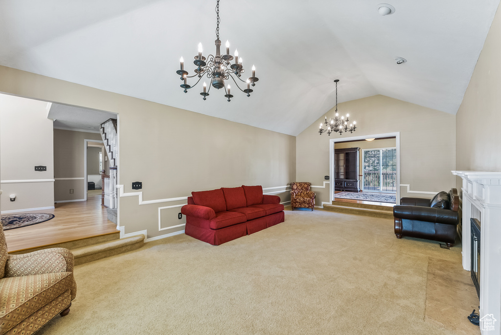 Living room with vaulted ceiling, carpet, and a chandelier