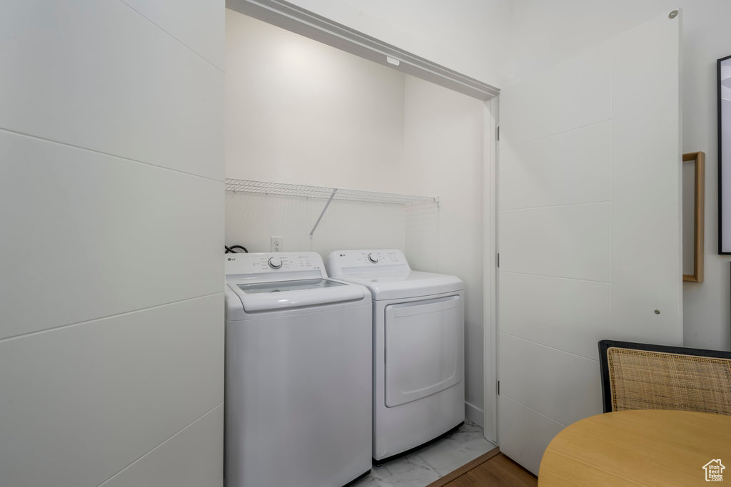 Laundry area featuring tile floors and washing machine and clothes dryer