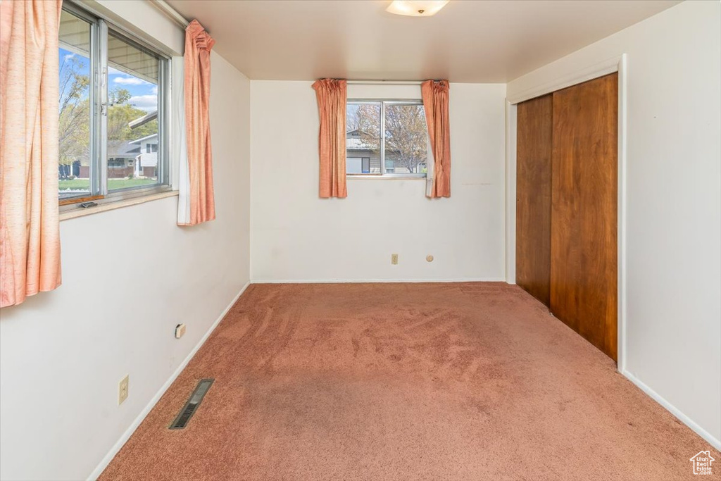 Unfurnished bedroom featuring carpet and multiple windows
