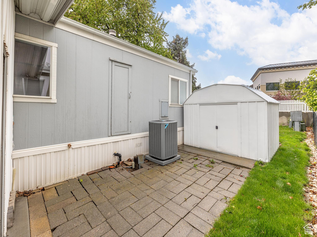 View of patio with central air condition unit and a storage shed