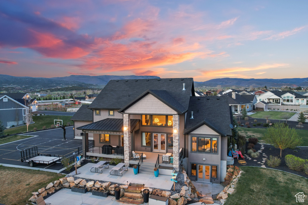 Back house at dusk with a patio area, an outdoor living space, and a mountain view