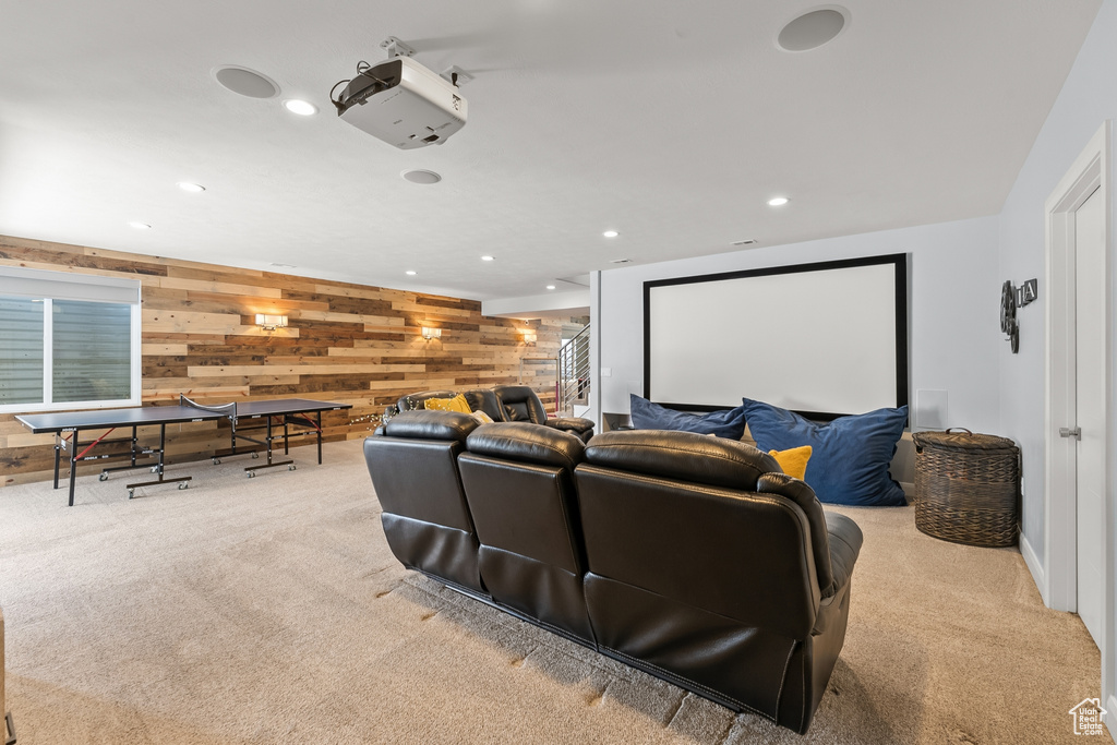 Carpeted home theater room featuring wood walls