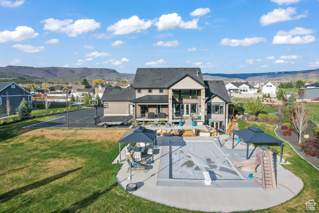 Rear view of house featuring a patio area, a mountain view, a fenced in pool, a gazebo, and a yard