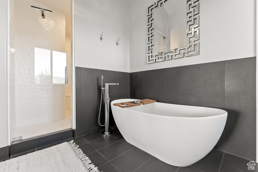 Bathroom featuring tile flooring, tile walls, and a washtub