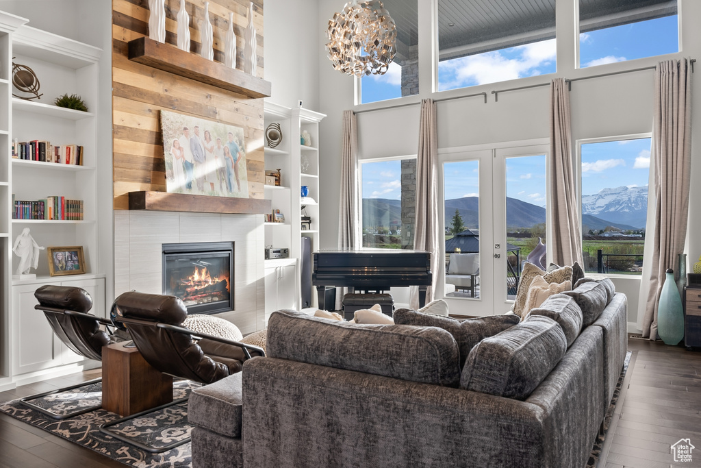 Living room featuring a mountain view, a tiled fireplace, built in features, and hardwood / wood-style floors