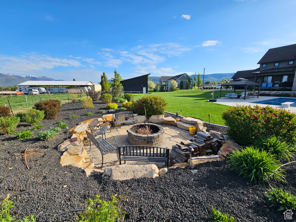 View of yard featuring a patio, an outdoor fire pit, and a mountain view