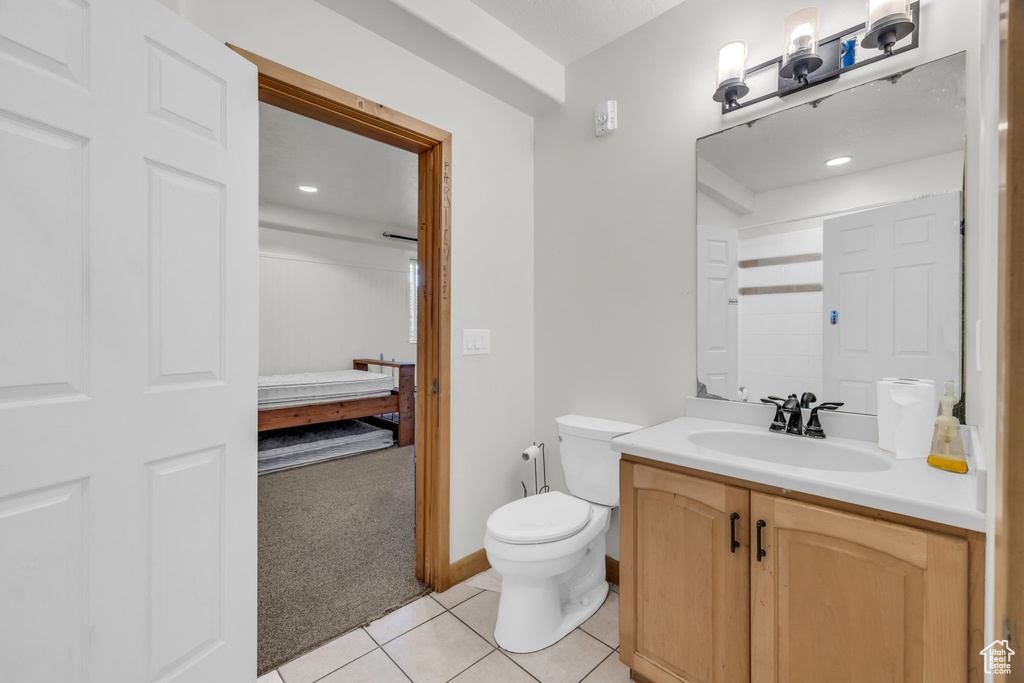 Bathroom with oversized vanity, toilet, and tile floors