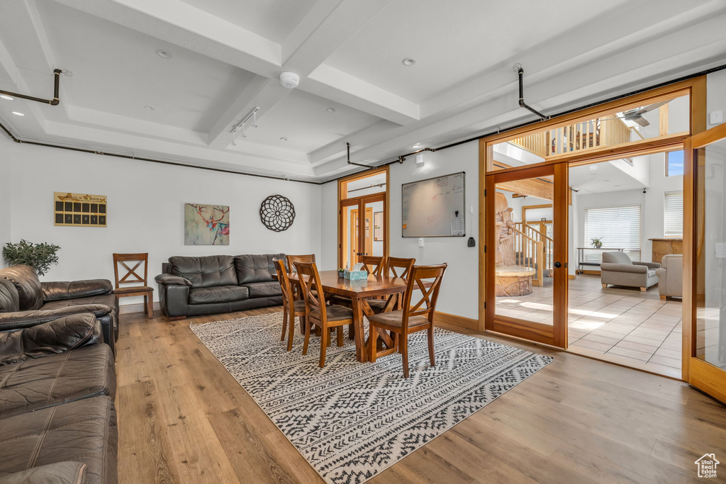 Dining space featuring beamed ceiling, light hardwood / wood-style flooring, french doors, and coffered ceiling