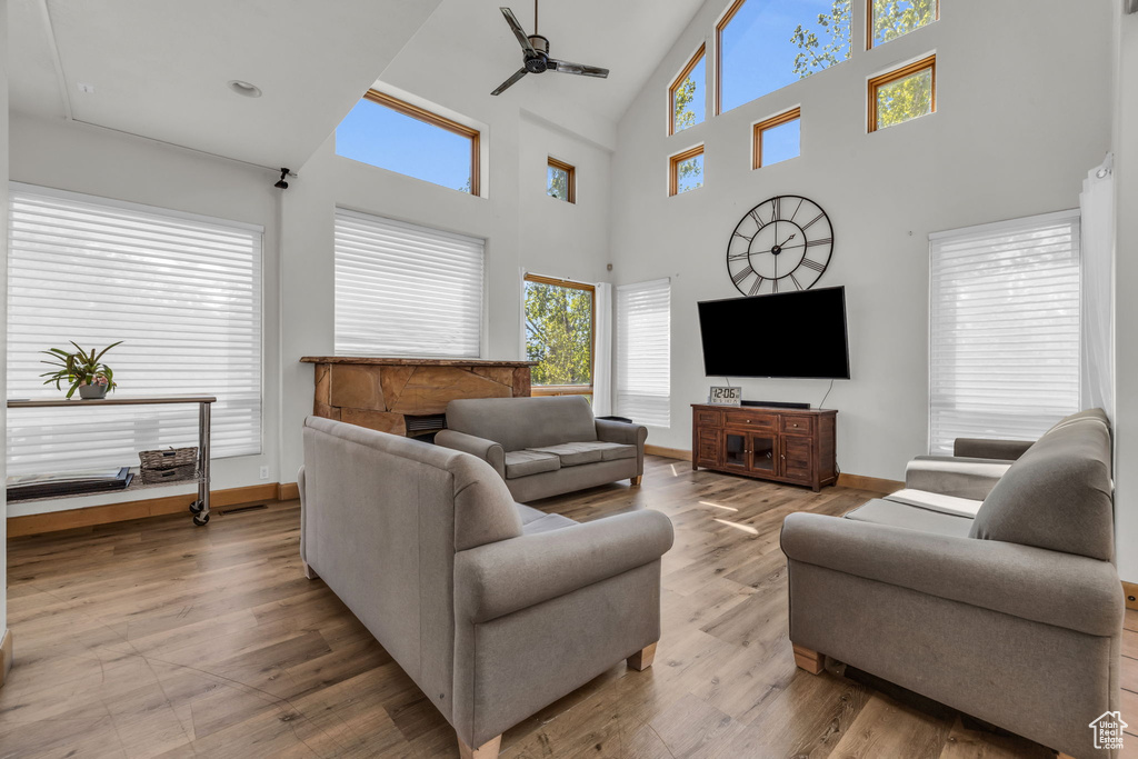 Living room featuring high vaulted ceiling, wood-type flooring, and ceiling fan