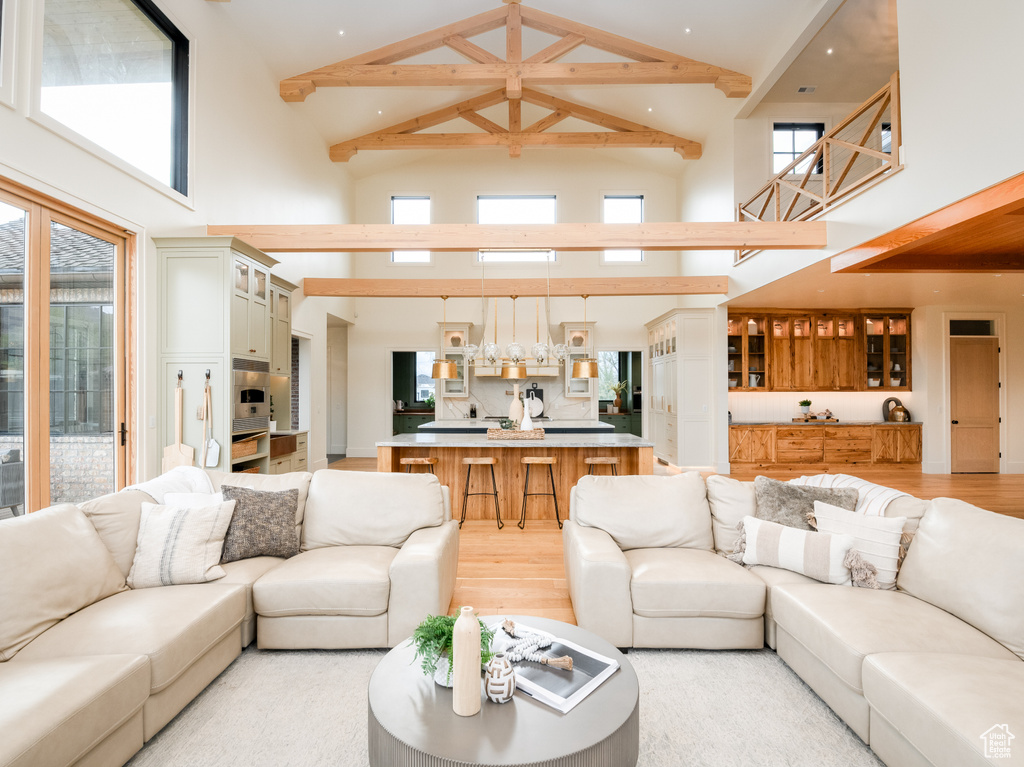 Living room with high vaulted ceiling and light wood-type flooring