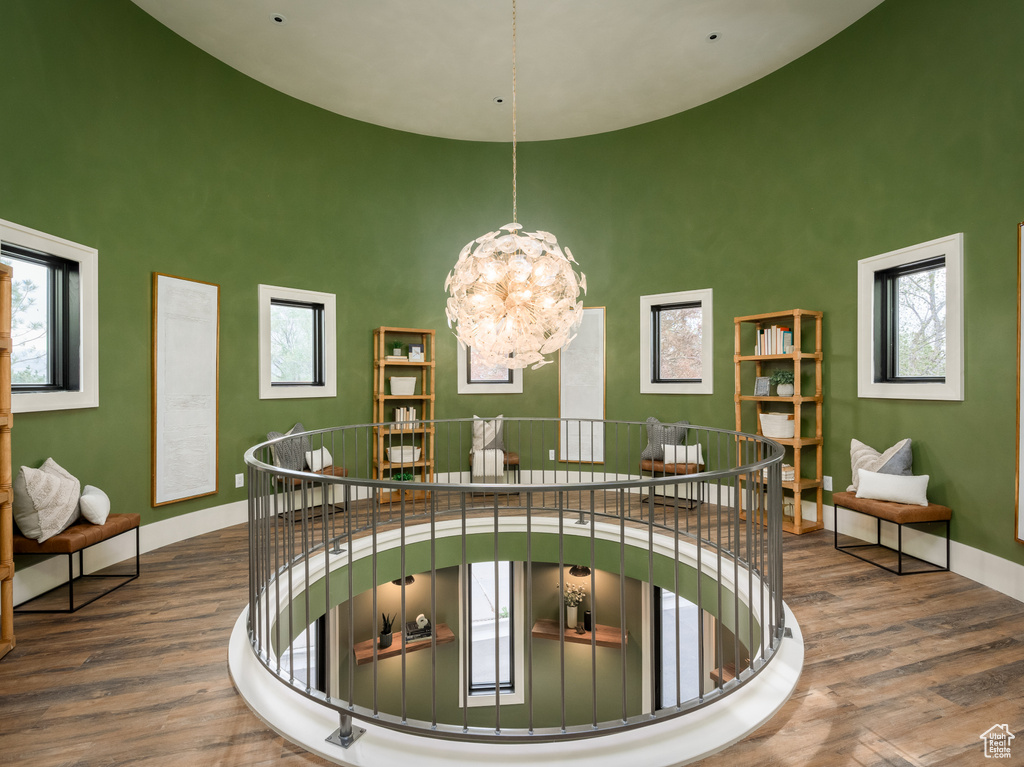 Interior space featuring dark hardwood / wood-style flooring, a chandelier, and a high ceiling