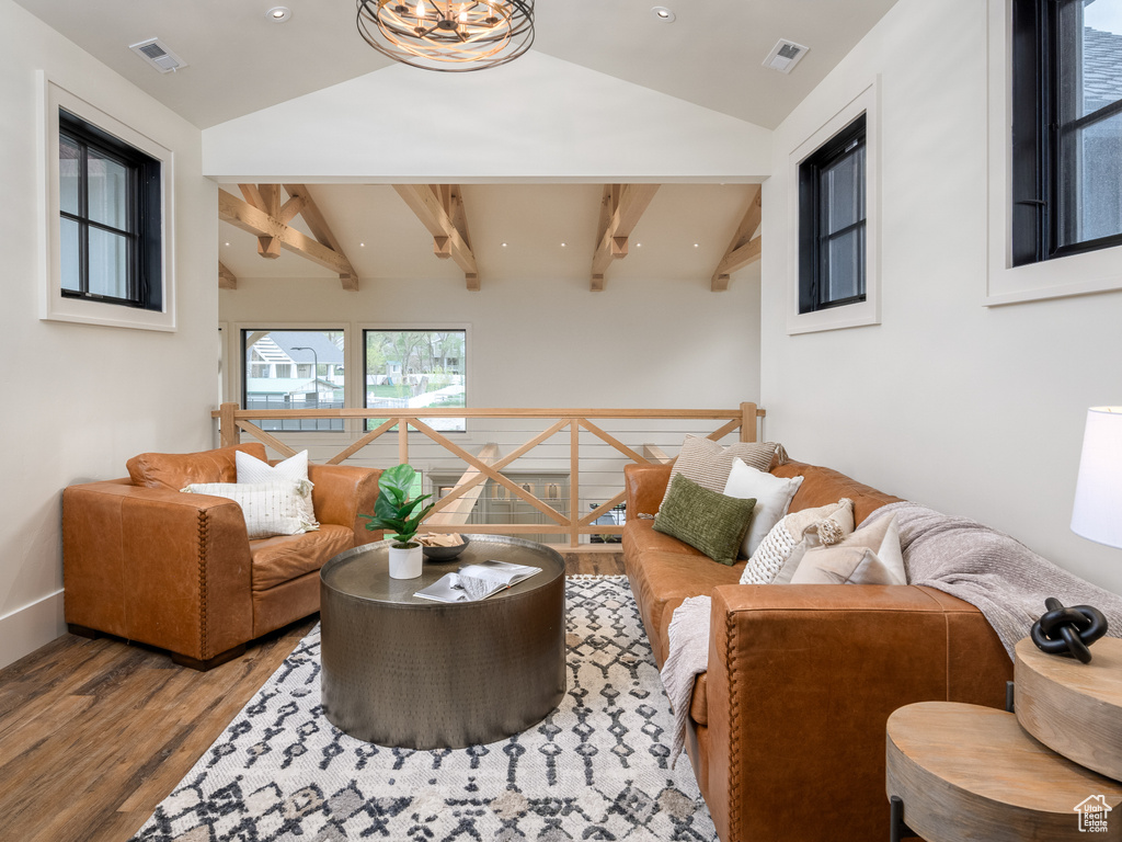 Living room featuring lofted ceiling with beams and hardwood / wood-style flooring