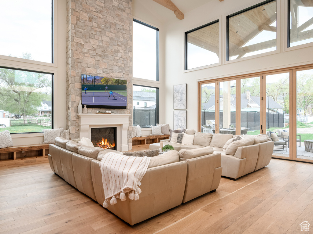Living room featuring light hardwood / wood-style flooring, a wealth of natural light, and a high ceiling