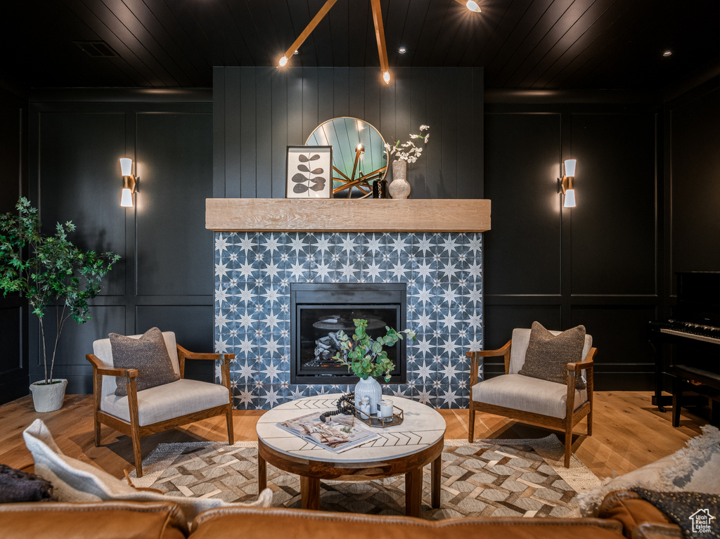 Living room with wood ceiling, light wood-type flooring, and a fireplace