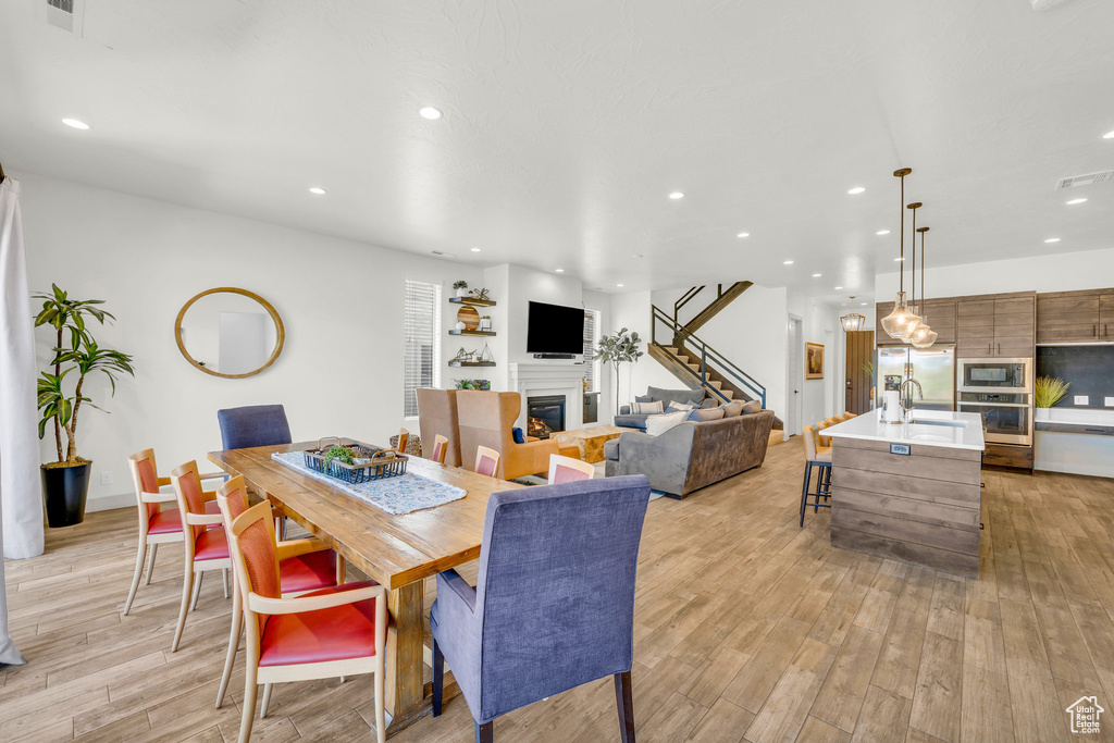 Dining space with sink and light wood-type flooring