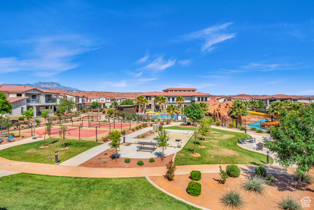 View of property's community with a swimming pool and a lawn