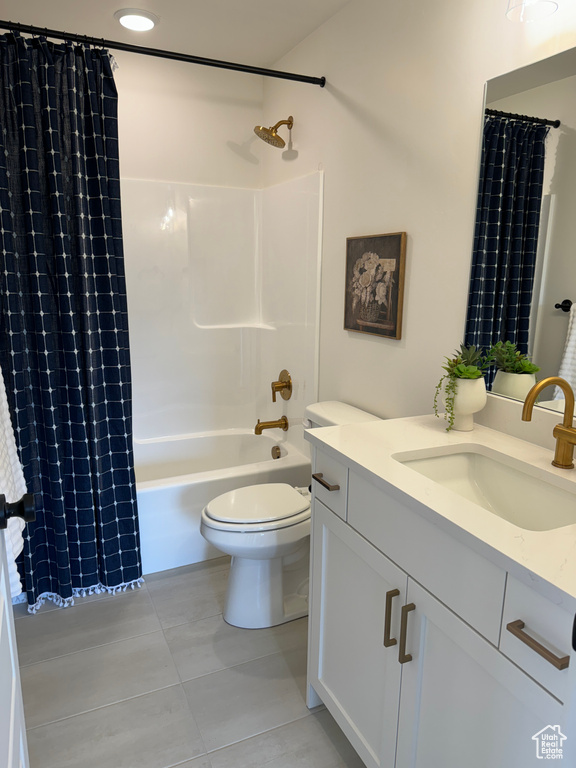 Full bathroom featuring vanity with extensive cabinet space, toilet, tile floors, and shower / tub combo with curtain