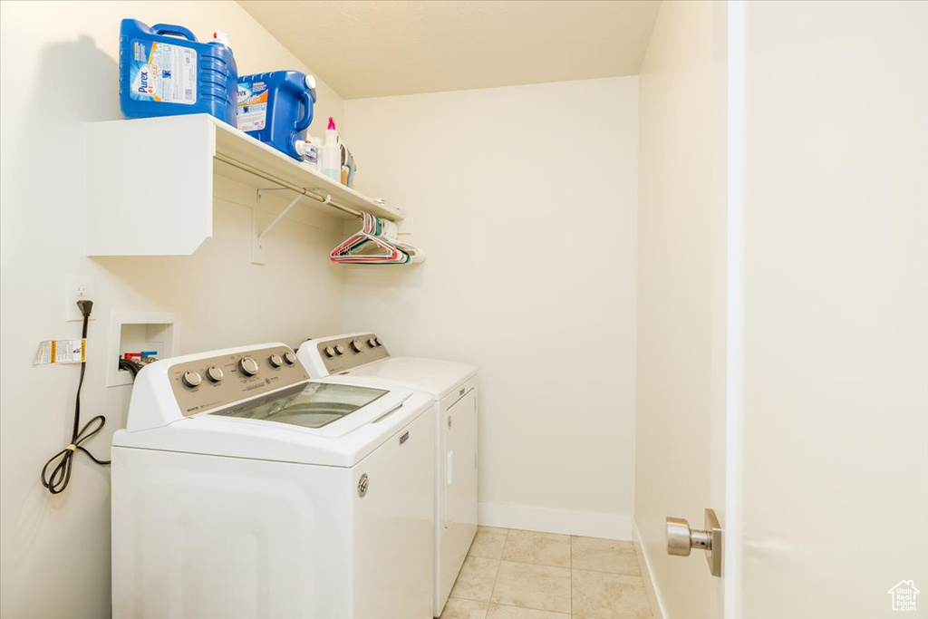 Clothes washing area with washer hookup, separate washer and dryer, and light tile floors