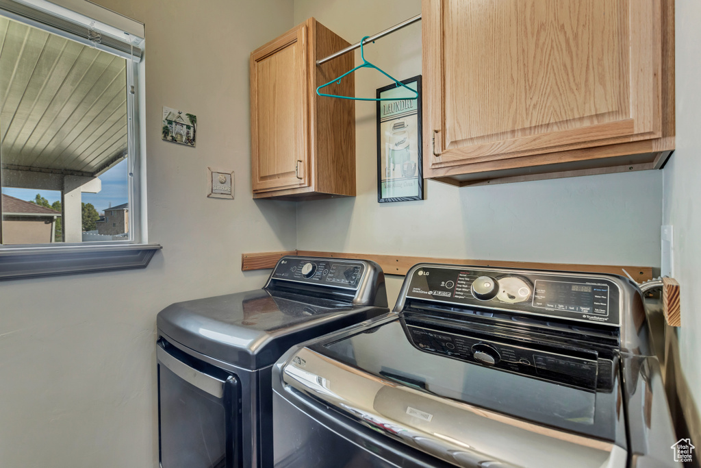 Laundry area featuring cabinets and separate washer and dryer