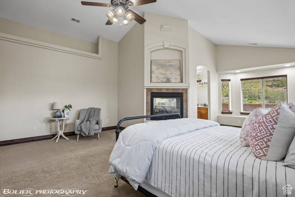 Bedroom with carpet flooring, high vaulted ceiling, ceiling fan, and a fireplace