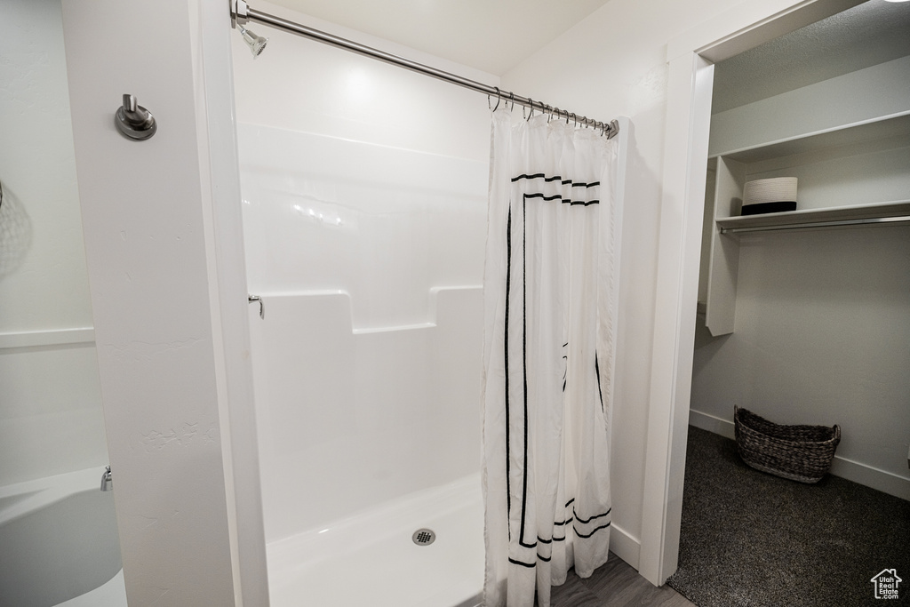Bathroom featuring a shower with shower curtain and hardwood / wood-style floors